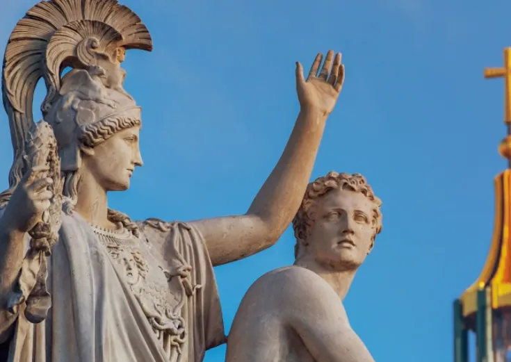 greek statues with one having a raised hand