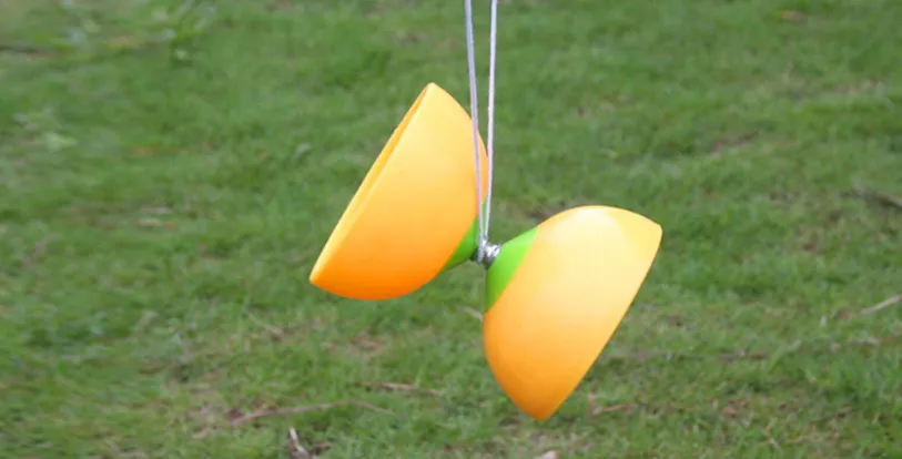 yellow diabolo toy suspended on string