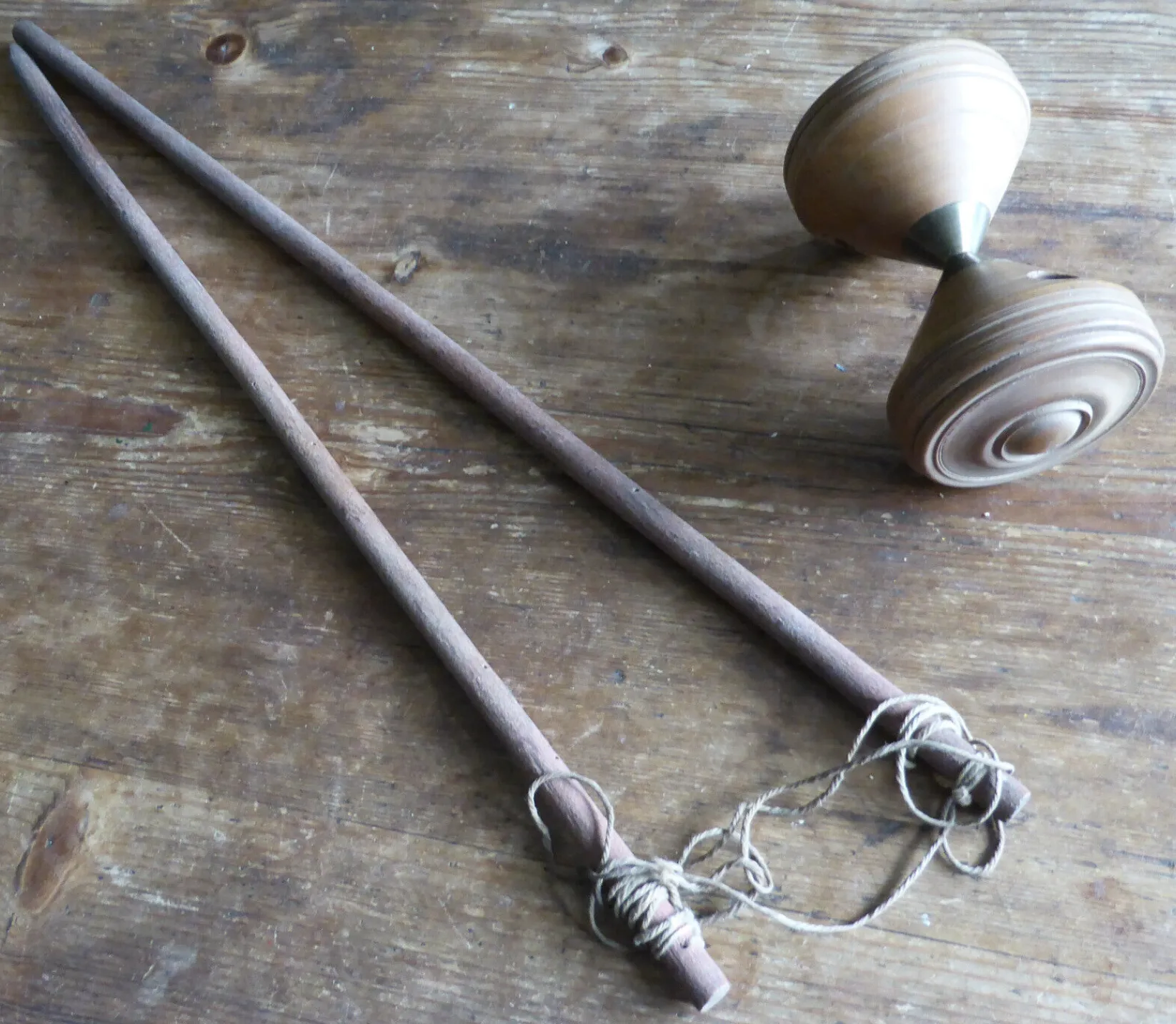 photograph of a vintage wooden diabolo toy with wooden sticks